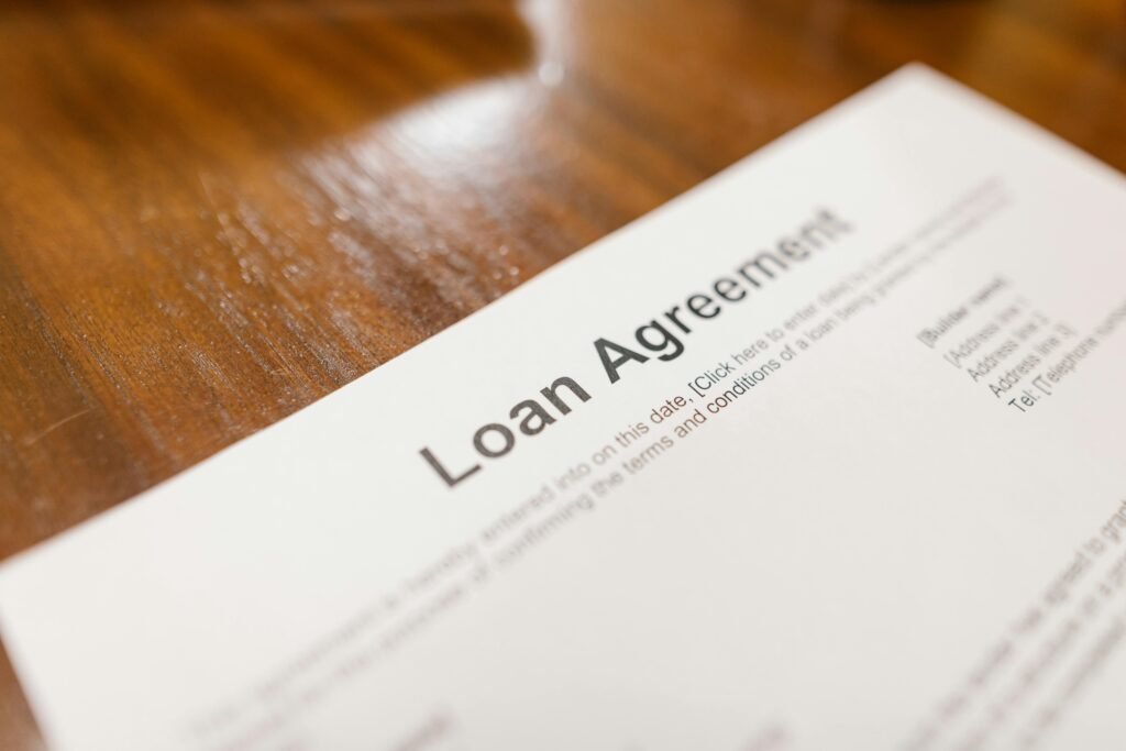 pexels-photo-7841821-7841821 Detailed loan agreement document close-up on a wooden table representing legal and financial concepts.