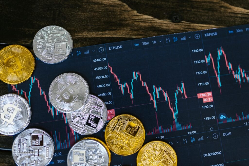 pexels-photo-8370752-8370752 Close-up of gold and silver cryptocurrency coins on a digital trading chart.
