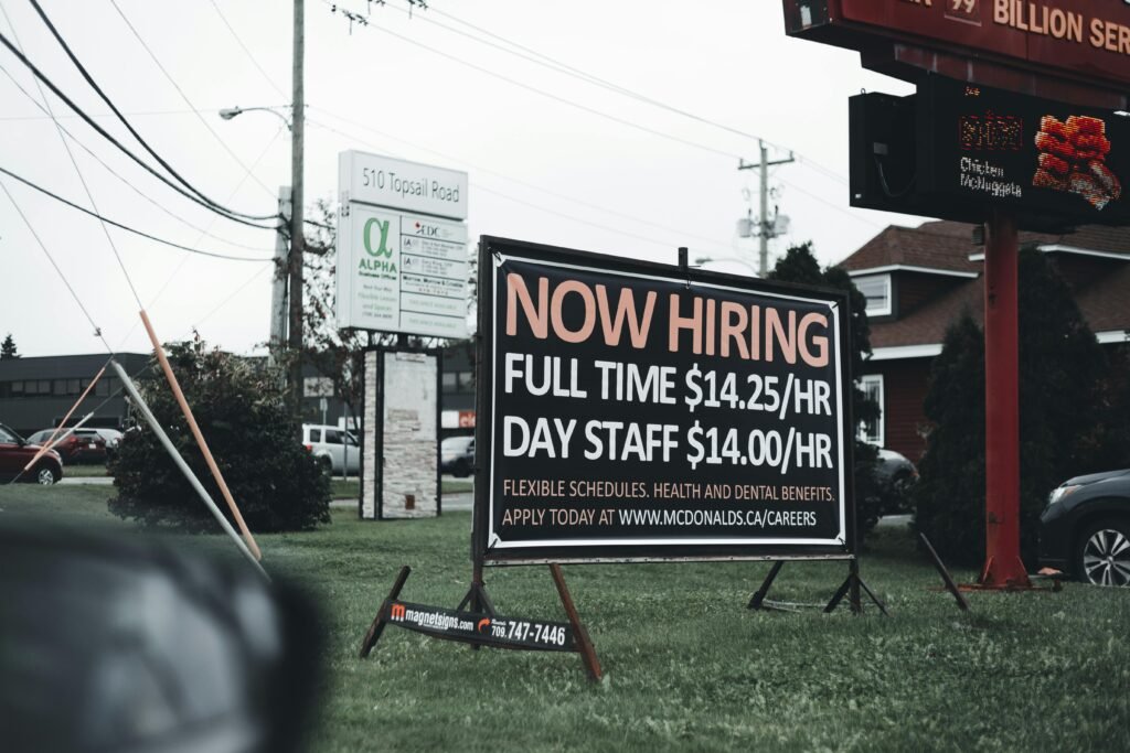 pexels-photo-9749091-9749091 Outdoor hiring sign advertising restaurant job openings with competitive wages and benefits.