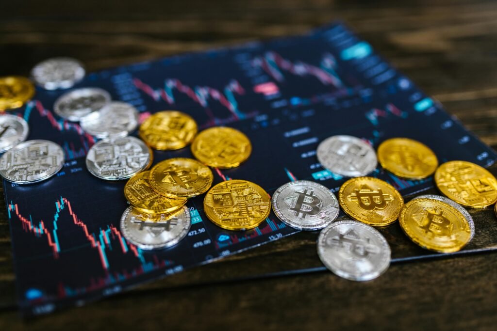 pexels-photo-8369682-8369682 Gold and silver Bitcoin coins on financial graph, symbolizing cryptocurrency trading and digital currency wealth.