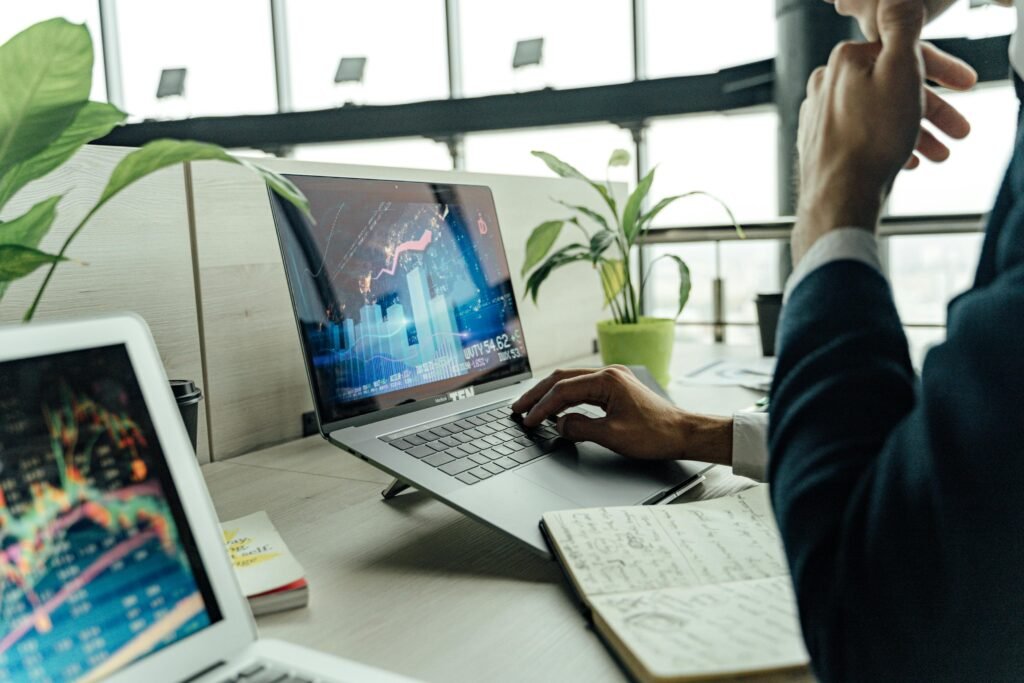 pexels-photo-5583972-5583972 A professional analyzing stock market data on a laptop in a bright office environment.