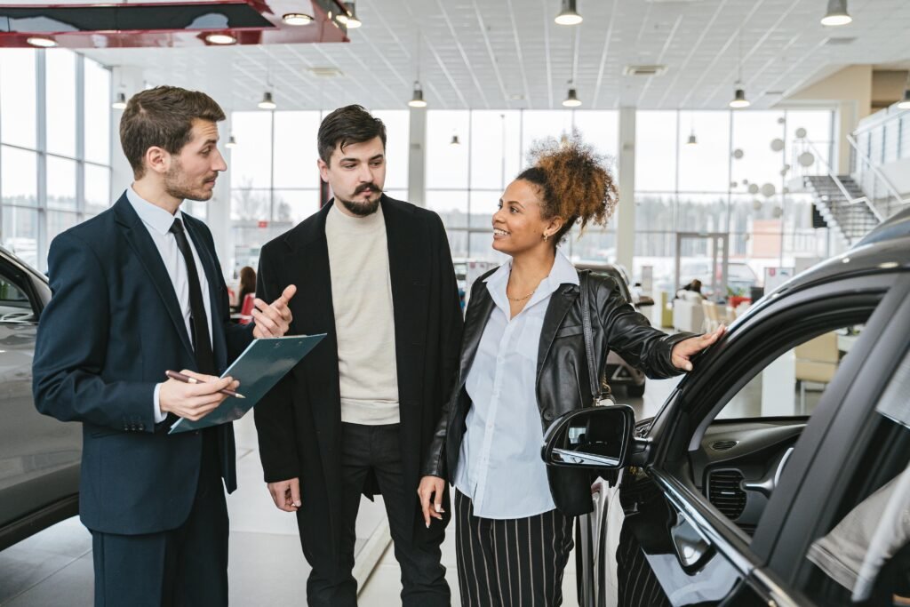 pexels-photo-7144177-7144177 A diverse team of adults discussing a car purchase in a dealership showroom.